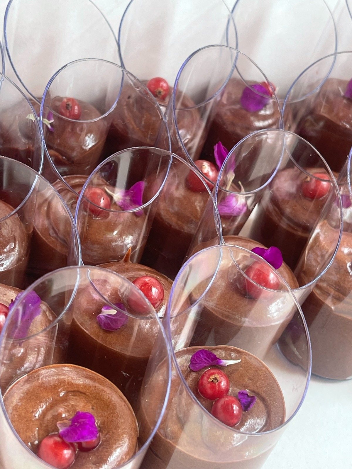 Vasitos de mousse de chocolate con grosellas y pétalos